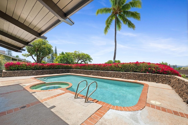 view of swimming pool with a patio and a pool with connected hot tub