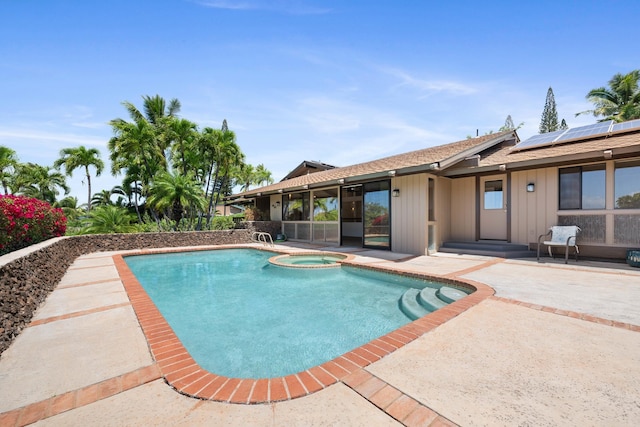 view of swimming pool with a patio, a pool with connected hot tub, and a sunroom