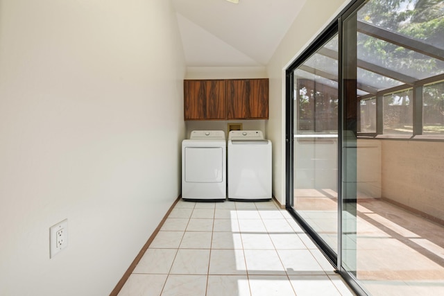 washroom featuring light tile patterned floors, cabinet space, plenty of natural light, and washer and clothes dryer