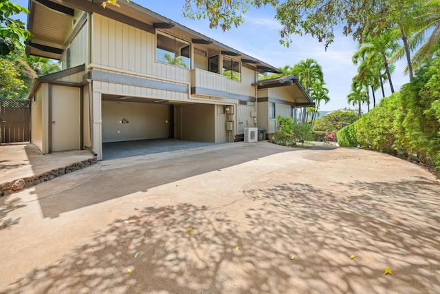 view of property featuring central AC, concrete driveway, and an attached garage