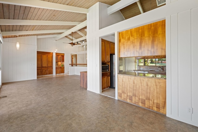 kitchen with stainless steel microwave, wood ceiling, lofted ceiling with beams, brown cabinetry, and a sink