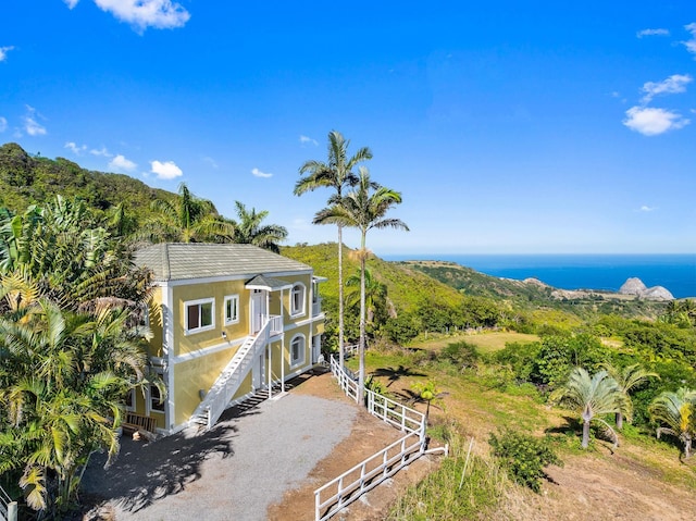 425 Kaukini Loop, Wailuku, HI 96793 - view of front of house with stucco siding, a balcony, and a water view