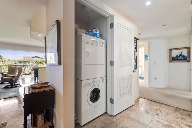 laundry area with light carpet and stacked washer and dryer