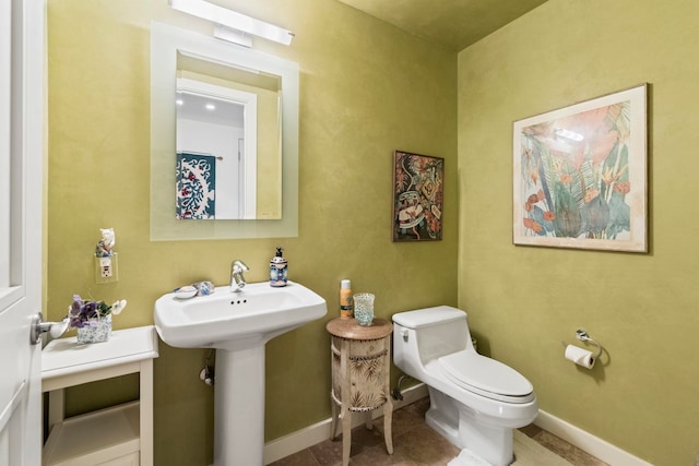 bathroom featuring tile patterned flooring, toilet, and sink