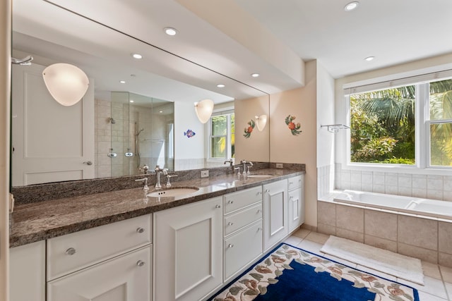 bathroom featuring tile patterned floors, vanity, plus walk in shower, and a wealth of natural light