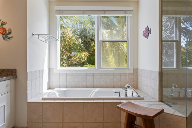 bathroom featuring tiled bath and vanity