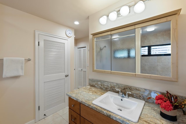 bathroom with tile patterned floors, walk in shower, and vanity