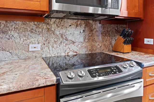 kitchen with appliances with stainless steel finishes and decorative backsplash