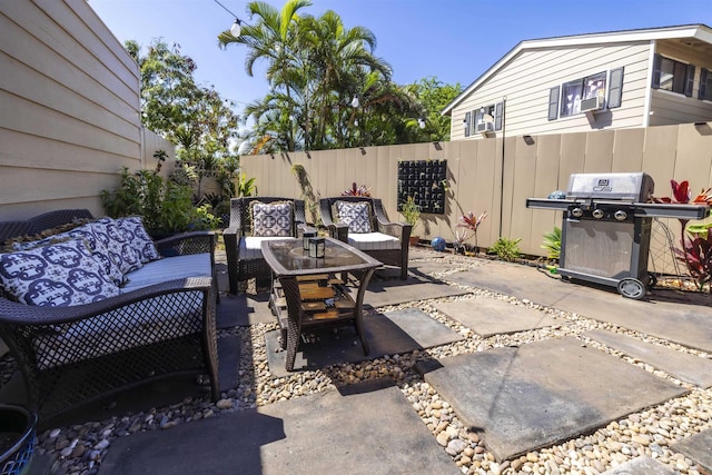 view of patio featuring grilling area, a fenced backyard, and an outdoor hangout area