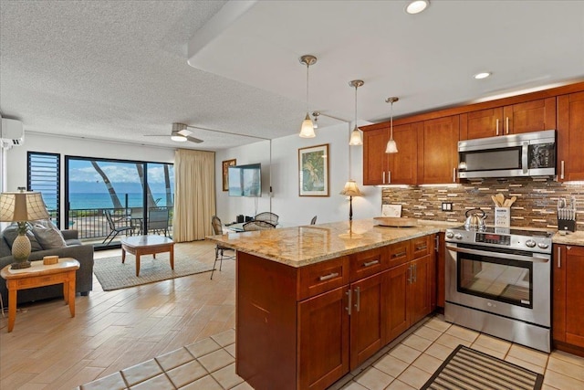 kitchen with kitchen peninsula, pendant lighting, appliances with stainless steel finishes, light stone counters, and a wall mounted AC