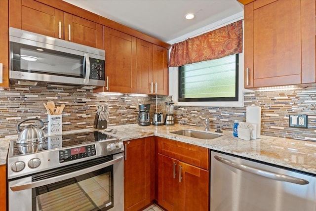 kitchen featuring sink, stainless steel appliances, light stone countertops, and backsplash