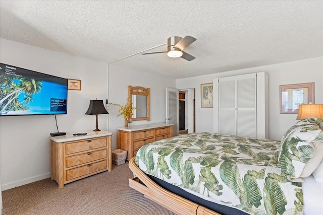 bedroom featuring ceiling fan, a textured ceiling, a closet, and carpet floors