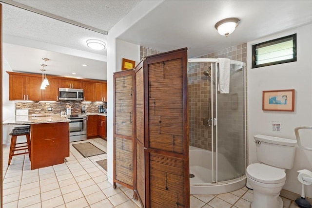 bathroom featuring tile patterned floors, vanity, tasteful backsplash, toilet, and walk in shower