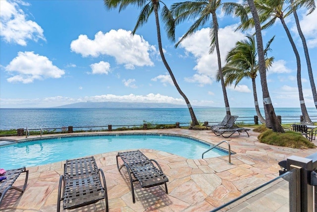 view of swimming pool with a patio area and a water view