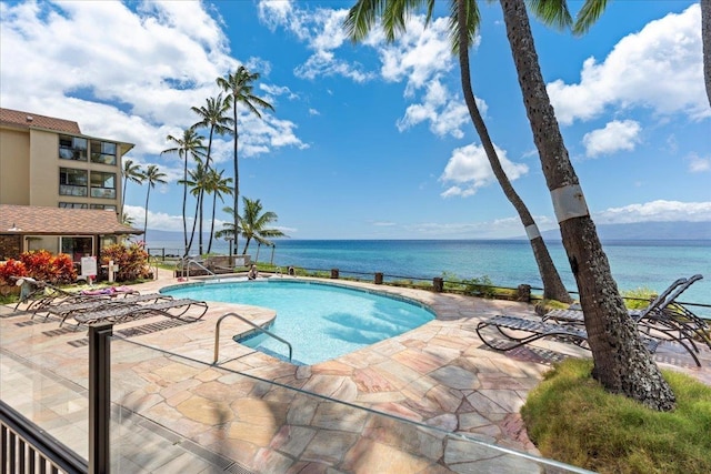 view of pool featuring a patio area and a water view