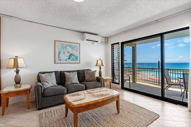 living room featuring a textured ceiling, a water view, and an AC wall unit