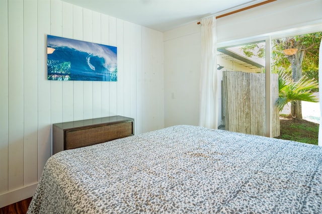 bedroom featuring wooden walls and hardwood / wood-style flooring