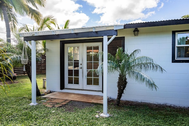 property entrance with a lawn and french doors