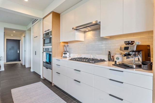 kitchen featuring tasteful backsplash, white cabinetry, and ventilation hood