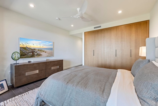 tiled bedroom with ceiling fan and a closet