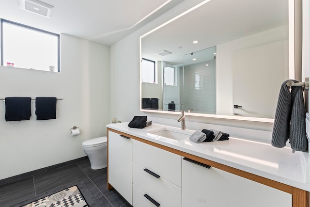 bathroom featuring vanity, toilet, and a shower with door