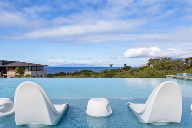 view of swimming pool with a water view