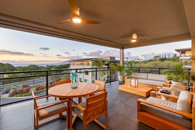 patio terrace at dusk featuring an outdoor living space, a balcony, and ceiling fan