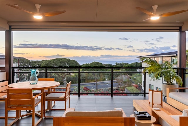 balcony at dusk featuring ceiling fan