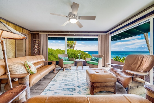 sunroom featuring a water view and ceiling fan