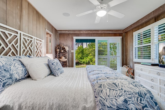 bedroom featuring access to exterior, ceiling fan, and wood walls