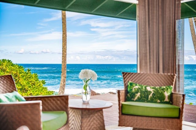 balcony featuring a view of the beach and a water view