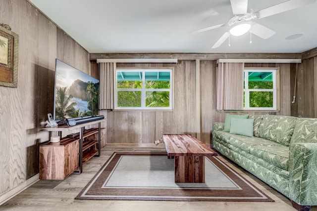 living room featuring wood walls, light hardwood / wood-style flooring, and ceiling fan