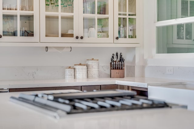 bar with white cabinets and stainless steel gas stovetop