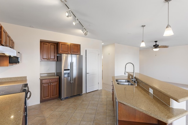 kitchen with black electric range oven, sink, hanging light fixtures, high quality fridge, and light stone countertops