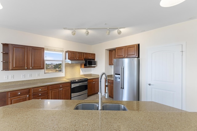 kitchen with light stone counters, appliances with stainless steel finishes, and sink