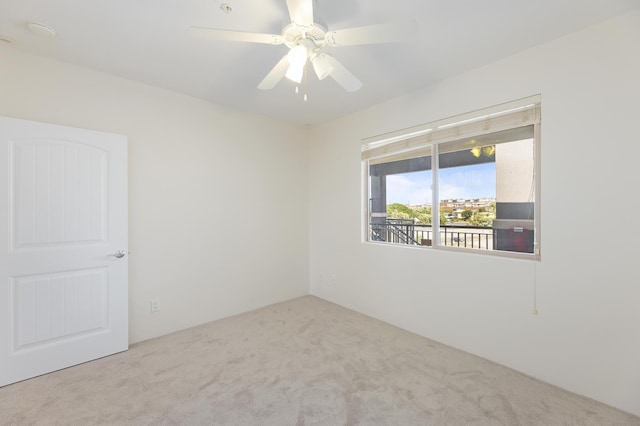 spare room with light colored carpet and ceiling fan