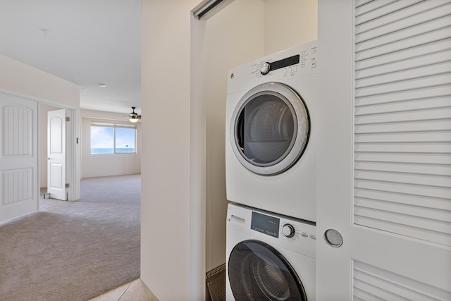 washroom featuring light carpet and stacked washing maching and dryer