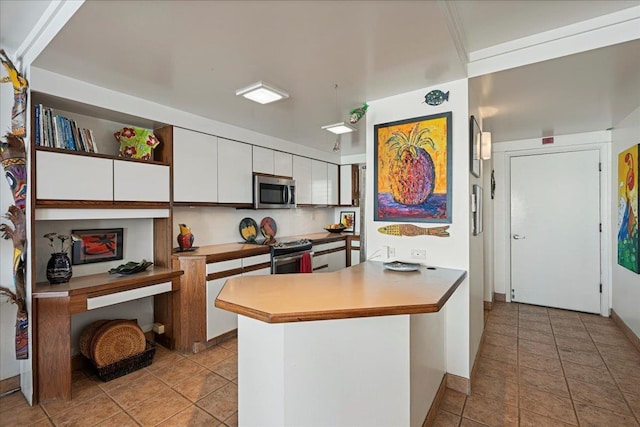 70 Hauoli St Unit 217, Wailuku, HI 96793 - kitchen with appliances with stainless steel finishes, white cabinets, a peninsula, light countertops, and light tile patterned flooring
