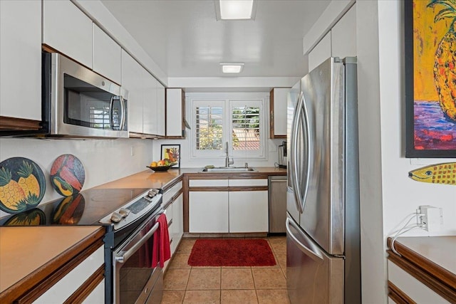70 Hauoli St Unit 217, Wailuku, HI 96793 - kitchen with stainless steel appliances, a sink, white cabinetry, and light tile patterned flooring
