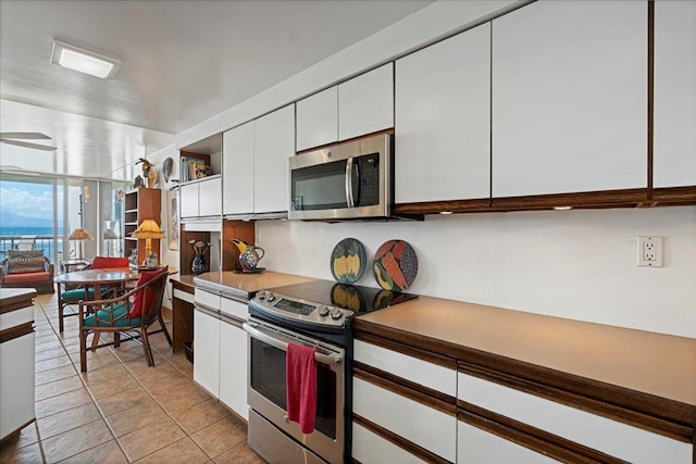 70 Hauoli St Unit 217, Wailuku, HI 96793 - kitchen featuring appliances with stainless steel finishes, white cabinets, light tile patterned floors, and light countertops