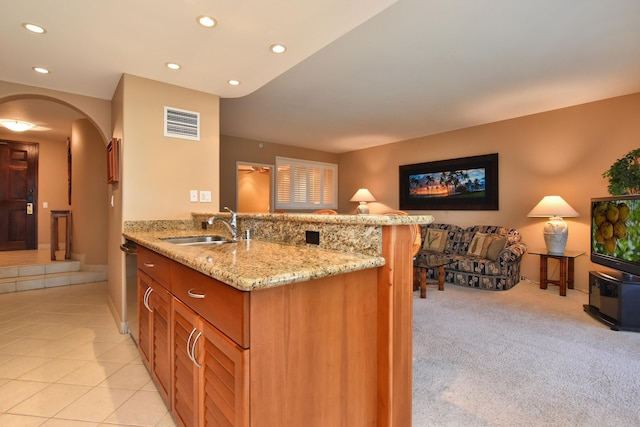 kitchen featuring light stone countertops, stainless steel dishwasher, sink, light colored carpet, and kitchen peninsula