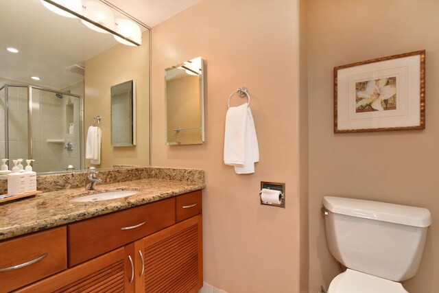 bathroom with vanity, toilet, and an enclosed shower