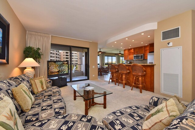 living room with light colored carpet and ceiling fan