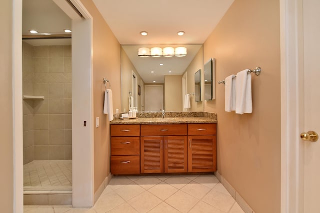 bathroom featuring vanity, tiled shower, and tile patterned flooring