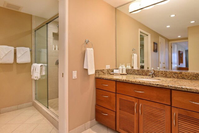 bathroom with tile patterned flooring, an enclosed shower, and vanity