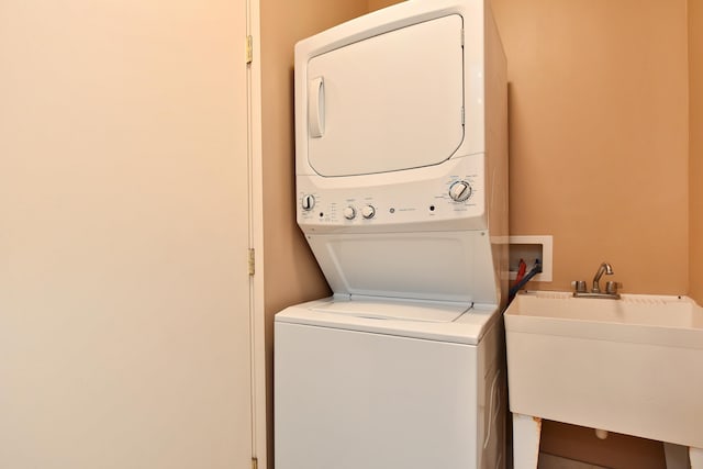 laundry room with stacked washer / dryer and sink