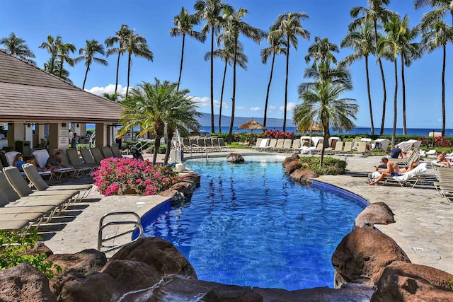 view of swimming pool with a water view and a patio area