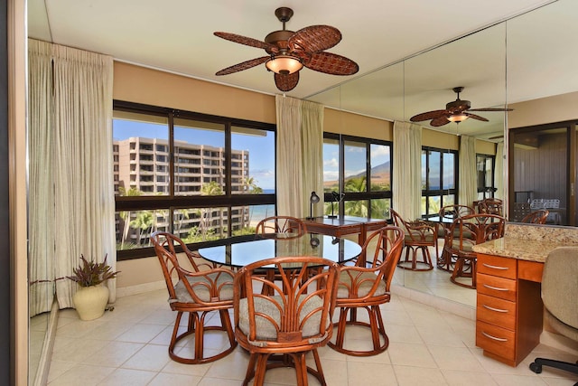 tiled dining room featuring plenty of natural light and ceiling fan