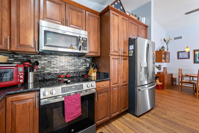 kitchen with light wood-style flooring, appliances with stainless steel finishes, and brown cabinetry