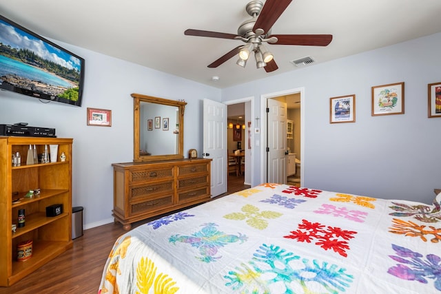 bedroom featuring dark wood-type flooring, ensuite bath, visible vents, and a ceiling fan